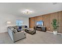 Spacious living room with comfortable gray sectional, wood accent wall, and tiled floors at 374 Pine Tree Bridge Trl, St Cloud, FL 34772