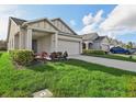 A view of the home's exterior, featuring an attached two-car garage, front yard, and tidy landscaping at 4324 Desert Rose, Kissimmee, FL 34746