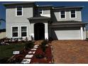Inviting two-story home showcasing a brick paved driveway and manicured landscaping at 4804 Marcos Cir, Kissimmee, FL 34758