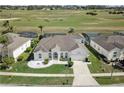 Aerial view of a home overlooking a golf course, featuring a well-manicured lawn at 520 Prestwick Dr, Davenport, FL 33897