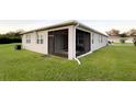 Exterior view of the screened-in lanai with a dark screen and views of the backyard at 5306 Meadow Song Dr, Okahumpka, FL 34762