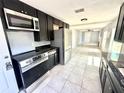 Charming kitchen with stainless steel appliances and black cabinets with black countertops at 6100 Skokie Rd, Lake Wales, FL 33898