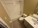 Bathroom featuring a white tiled shower-tub, toilet, and vanity with sink at 709 Orchid Dr, Davenport, FL 33897