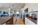 Bright, open kitchen with stainless appliances, dark counters, and a seamless flow into the dining area at 738 Lake Dell Ave, Dundee, FL 33838