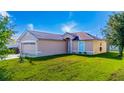 A charming single-story house with a manicured lawn, features a front door and two-car garage at 802 Massy Ct, Kissimmee, FL 34759