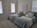 Comfortable bedroom with two twin beds, neutral tones, and natural light from the window at 8270 Topsail Pl, Winter Garden, FL 34787
