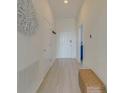 Bright hallway features wood-look floors, fresh white walls and a decorative wicker accent piece at 926 Balmoral Dr, Davenport, FL 33896