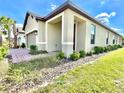 Stunning single-Gathering home showcasing manicured landscaping, side entry, and inviting front porch at 1001 Umbria Dr, Poinciana, FL 34759
