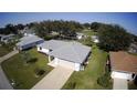 Aerial view showcasing the home's exterior, lush lawn, and mature trees at 10237 Sw 63Rd Ave, Ocala, FL 34476