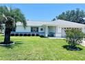 Charming single-story home featuring a well-manicured lawn, shrubbery, and a shade tree at 10237 Sw 63Rd Ave, Ocala, FL 34476