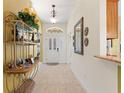 Inviting entryway featuring tiled floors, decorative shelving, and a view to the interior spaces at 1258 Donalds Pl, The Villages, FL 32162