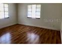 Bright bedroom featuring hardwood floors and natural light streaming through the large windows at 1309 N Thacker Ave, Kissimmee, FL 34741