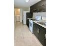 Galley kitchen with modern dark wood cabinetry, light countertops, and white appliances at 1309 N Thacker Ave, Kissimmee, FL 34741