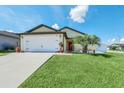 Charming single-Gathering home boasting a well-manicured lawn and a two-car garage for ultimate curb appeal at 1602 Steely Dr, Dundee, FL 33838