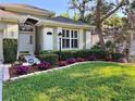 Close-up of front yard with lush green grass, flowering shrubs, and well maintained garden beds at 1784 Sparkling Water Cir, Ocoee, FL 34761