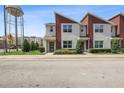 Modern townhouse exterior with well-maintained landscaping, set against a bright sky and urban backdrop at 185 E Warren Ave, Longwood, FL 32750