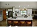 Modern kitchen with white cabinetry, stainless appliances, an island with seating, and wood-style flooring at 2074 Dunsford Dr, Orlando, FL 32808