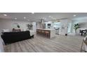 Open floor plan showcasing the kitchen, living room and dining area with wood-look floors and recessed lighting at 2074 Dunsford Dr, Orlando, FL 32808