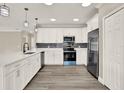 Bright kitchen featuring quartz countertops, white cabinetry, stainless steel appliances and a stylish backsplash at 242 Anson Dr, Kissimmee, FL 34758