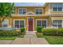 Charming two-story townhome with red door, white picket fence, and lush landscaping at 2614 Lodi Cir # 106, Kissimmee, FL 34746