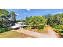 Aerial view of a charming two-story home with brick driveway, mature trees and lush greenery around the property at 2652 N Woodland Blvd, Deland, FL 32720