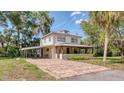 Charming two-story home features a covered porch and carport, complemented by a brick driveway at 2652 N Woodland Blvd, Deland, FL 32720