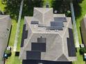 Aerial view of a home with solar panels on the roof and a well-manicured lawn at 3003 Cobham Rd, Kissimmee, FL 34758