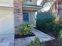 Well-maintained front entrance with a walkway leading to the door and lush landscaping at 3003 Cobham Rd, Kissimmee, FL 34758