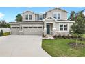 Inviting two-story home with a three-car garage, stone accents, and a well-manicured lawn at 3629 Sublett Loop, Tavares, FL 32778