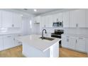 Bright kitchen featuring white cabinetry, stainless steel appliances, and a stylish island with seating at 3629 Sublett Loop, Tavares, FL 32778