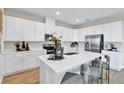 Bright kitchen with stainless steel appliances, a large island with barstool seating, and modern finishes at 4071 Bannock Ave, Tavares, FL 32778