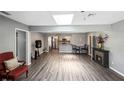 Open-concept living room boasts wood floors, skylight, and seamless flow to the kitchen at 4218 Drexel Ave, Orlando, FL 32808