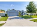 Well-maintained home featuring a spacious driveway and a beautiful blue exterior at 501 Pheasant Dr, Haines City, FL 33844