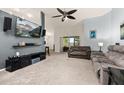 Comfortable living room with vaulted ceilings, neutral carpet, and a sliding glass door at 501 Pheasant Dr, Haines City, FL 33844