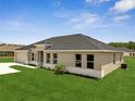 Side exterior shot showing the yard and neutral color palette with a gray roof at 555 Viceroy Ct, Kissimmee, FL 34758