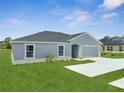 Well-maintained single-story home with a manicured lawn and a driveway at 557 Viceroy Ct, Kissimmee, FL 34758