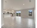 Open-concept living room and kitchen with tile flooring and stainless steel appliances at 557 Viceroy Ct, Kissimmee, FL 34758