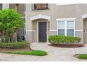 Townhouse entrance featuring a dark door, manicured shrubs, and a window for natural light at 6548 Swissco Dr # 61, Orlando, FL 32822