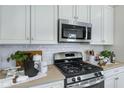 Close-up of a kitchen featuring stainless steel appliances, light countertops and white backsplash at 713 Lake Dell Ave, Dundee, FL 33838