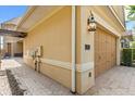 Exterior view of a home featuring tan stucco and a beige two-car garage at 781 Golden Bear Dr, Kissimmee, FL 34747