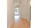 Bright hallway with hardwood floors that leads to a room with a sliding glass door and pool view at 847 Orista Dr, Davenport, FL 33897