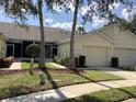 Charming villa with a well-maintained lawn, tidy landscaping, and an attached one-car garage at 88 Club Villas Ln, Kissimmee, FL 34744