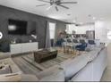 Open-concept living room flowing into the modern kitchen with counter seating at 9118 Sommerset Hills Dr, Davenport, FL 33896