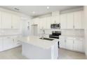 Modern kitchen featuring white cabinets, quartz countertops, and stainless steel appliances at 1027 Cloud Ridge Ct, Mount Dora, FL 32757