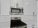 Close-up of a modern kitchen with stainless steel appliances and white subway tile backsplash at 1035 Cloud Ridge Ct, Mount Dora, FL 32757