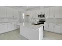 Modern kitchen with white cabinets, stainless steel appliances, a large island, and ample counter space at 1051 Cloud Ridge Ct, Mount Dora, FL 32757