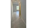 Bright hallway with neutral tile flooring leading to a room with a large window at 1053 Waterfall Blvd, Davenport, FL 33837