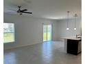 Open-concept living room with tile floors, a ceiling fan, and sliding glass doors at 1053 Waterfall Blvd, Davenport, FL 33837