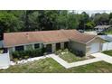 Exterior view of the home featuring a one-car attached garage and well-manicured lawn at 114 N Alderwood St, Winter Springs, FL 32708