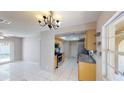 Bright kitchen adjacent to a dining area, featuring tile flooring and stainless steel appliances at 114 N Alderwood St, Winter Springs, FL 32708